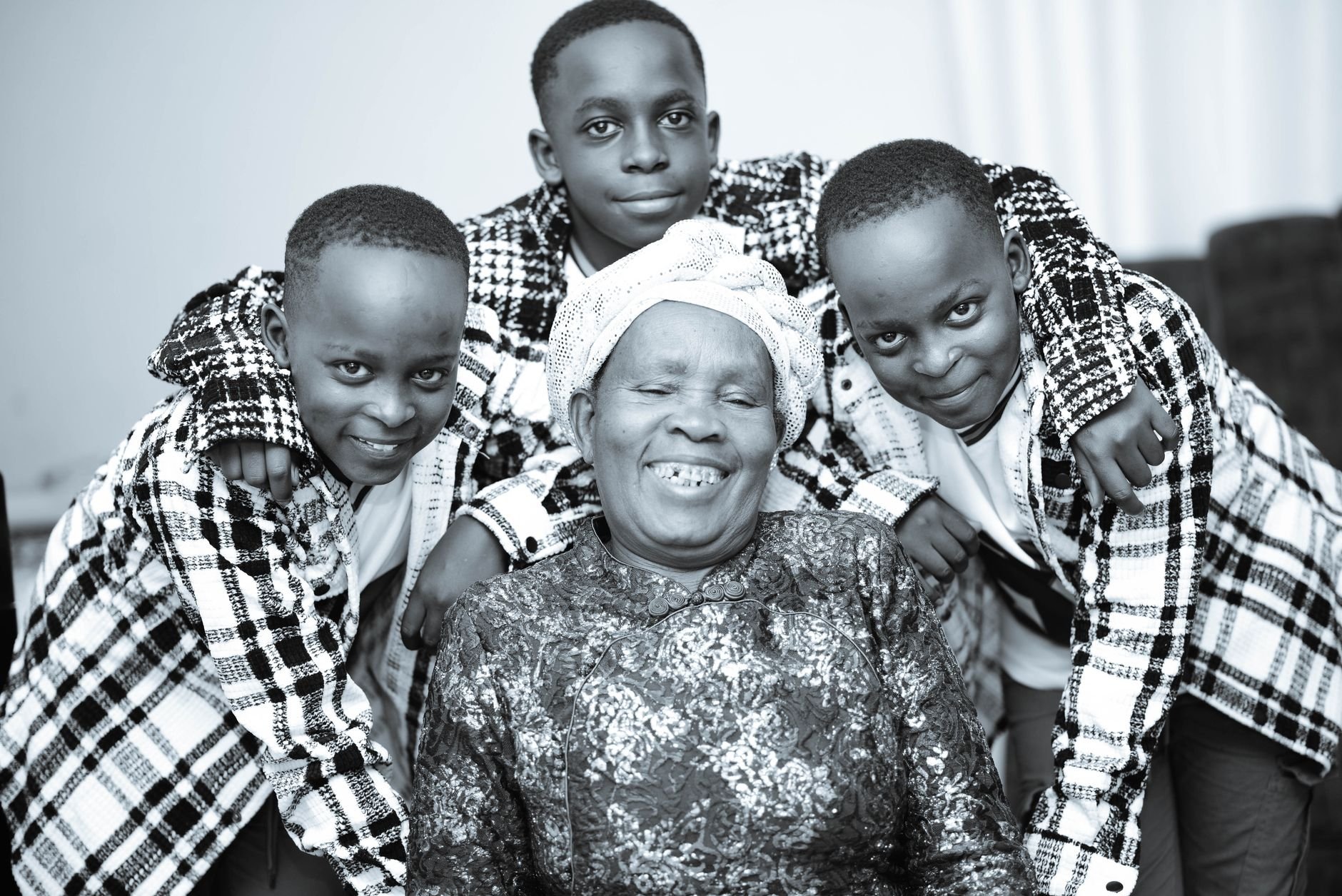 Elderly woman with her cheerful grandchildren embracing her warmly indoors.